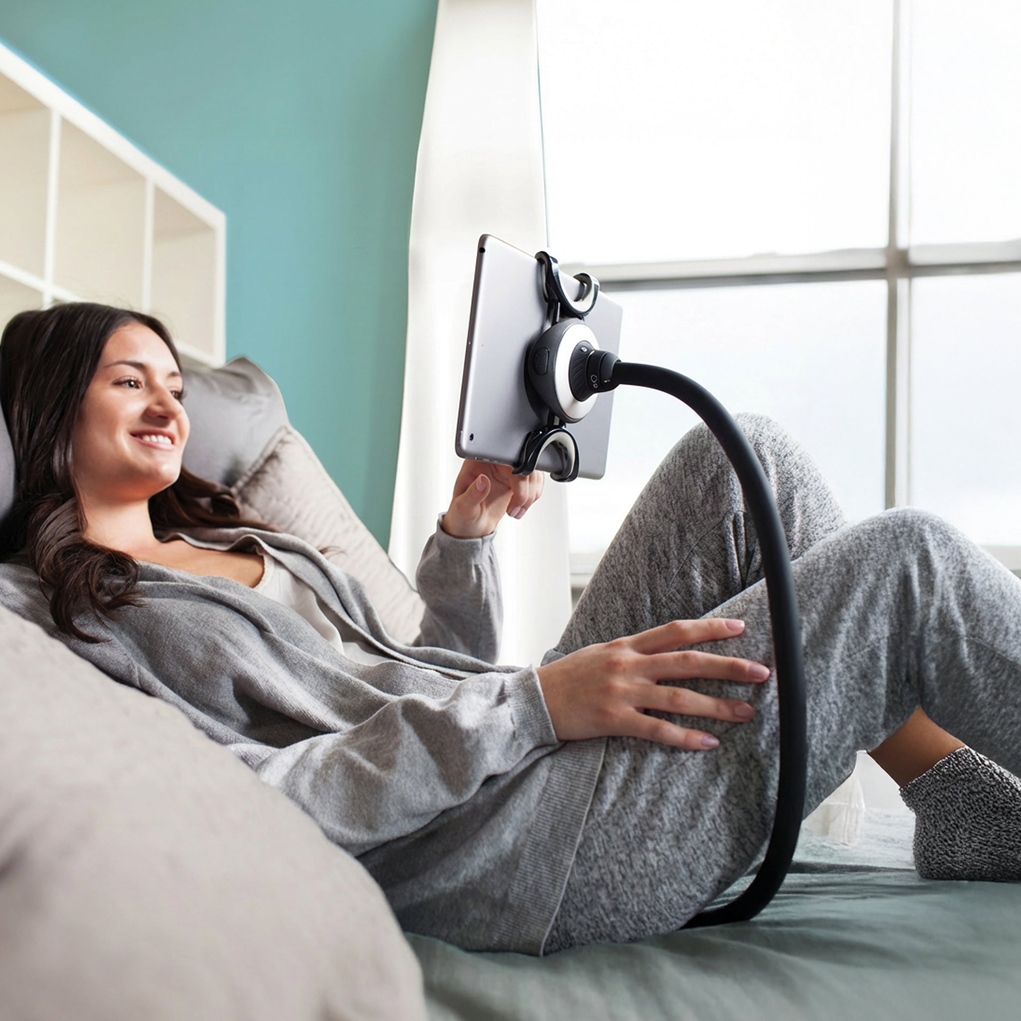 Spider Monkey holding a tablet hands-free in bed